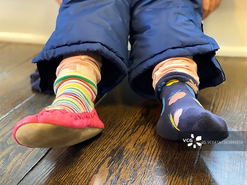 穿着雪裤的年轻混血女孩坐在台阶上，准备去外面玩雪图片素材