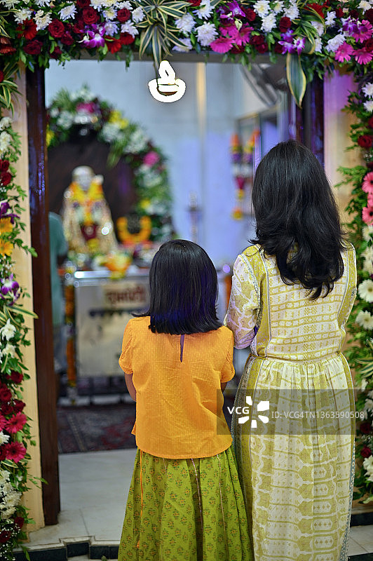 在印度教寺庙里祈祷的母女背影图片素材