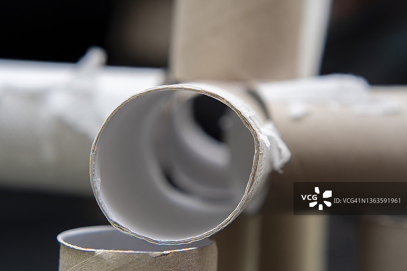 深色背景下的空卫生纸卷特写，生态与材料回收主题背景图片素材