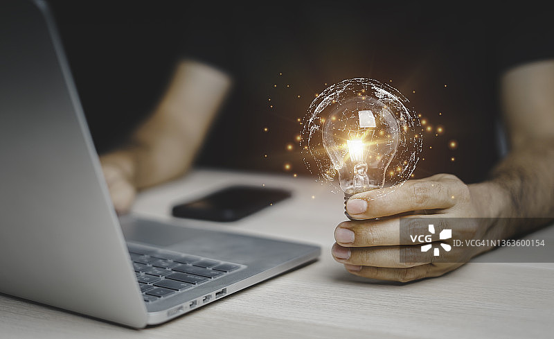 男人们触摸明亮的灯泡，展示新作品，思考未来的创新理念图片素材