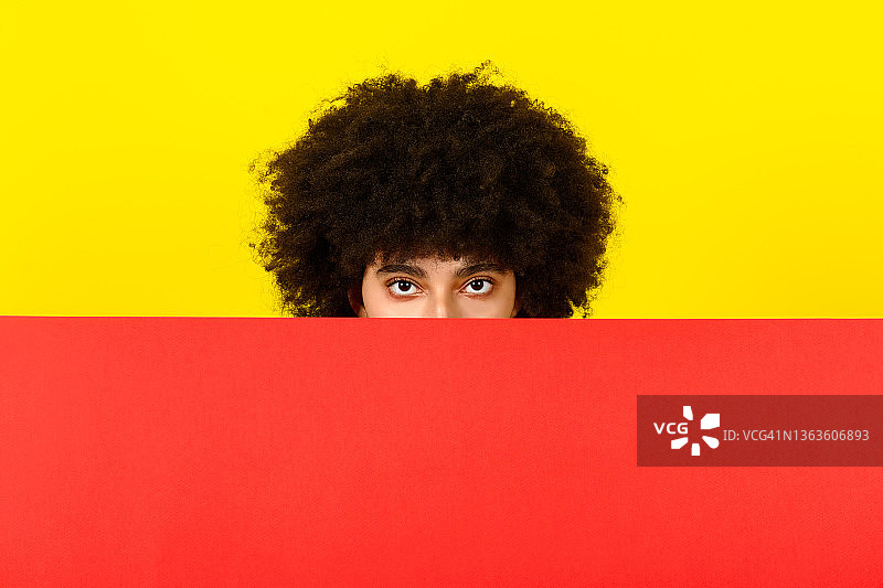 漂亮非洲年轻女子留着有趣的非洲发型偷看，时尚艺术彩色概念图片素材
