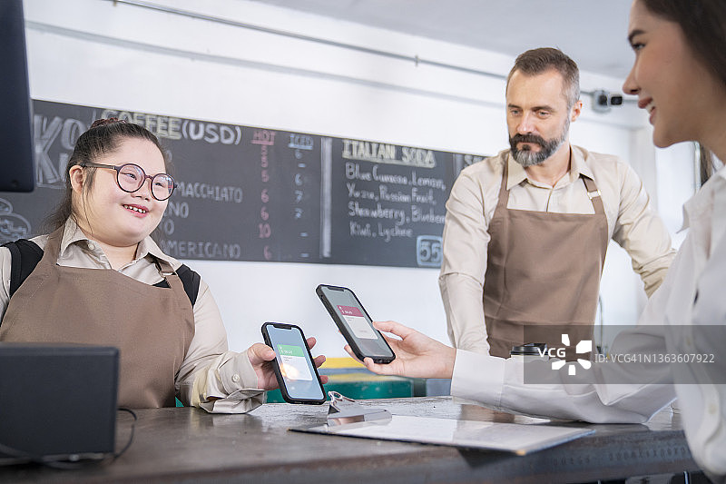 收银员在咖啡店通过智能手机接收顾客付款图片素材
