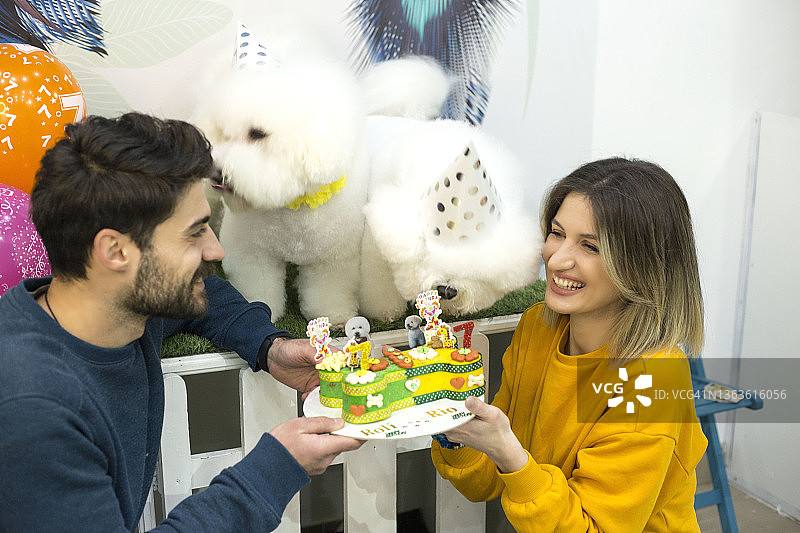年轻夫妇庆祝他们狗狗的生日图片素材