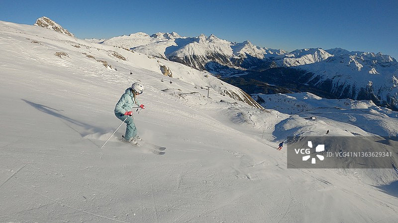 在阳光明媚的阿尔卑斯山上滑雪的女人图片素材