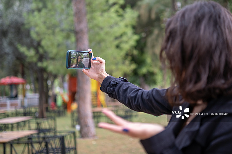 年轻女子在秋季假期拍摄Vlog图片素材