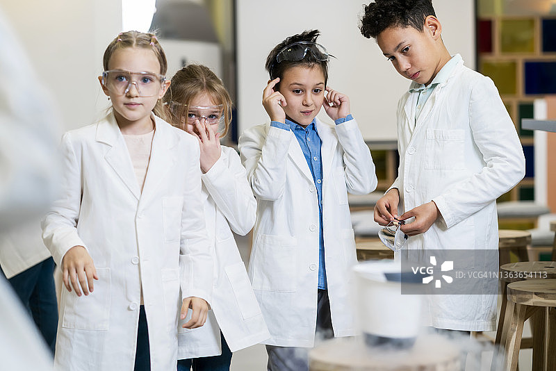 不同的小学生与老师一起进行科学项目图片素材