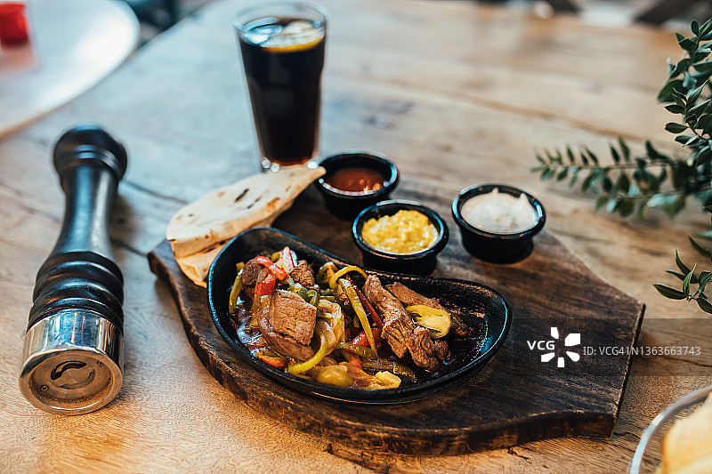 搭配彩色甜椒和玉米饼的铁板牛肉法士达图片素材