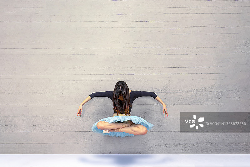 在水泥墙前起舞的芭蕾舞演员图片素材