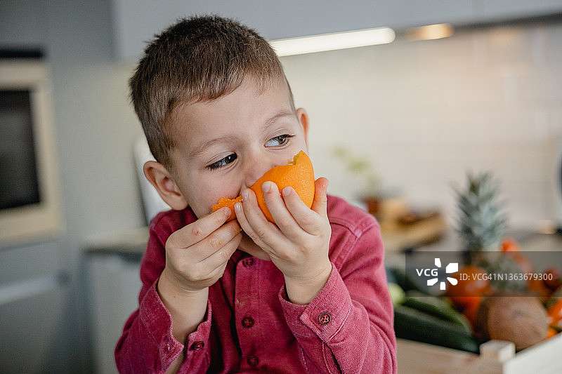 在家吃橘子的可爱小男孩图片素材