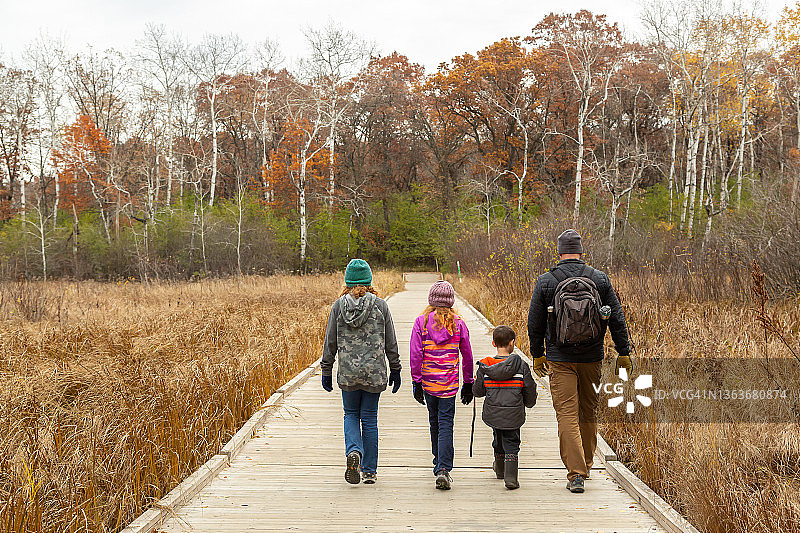秋季一家人走过木制浮桥图片素材