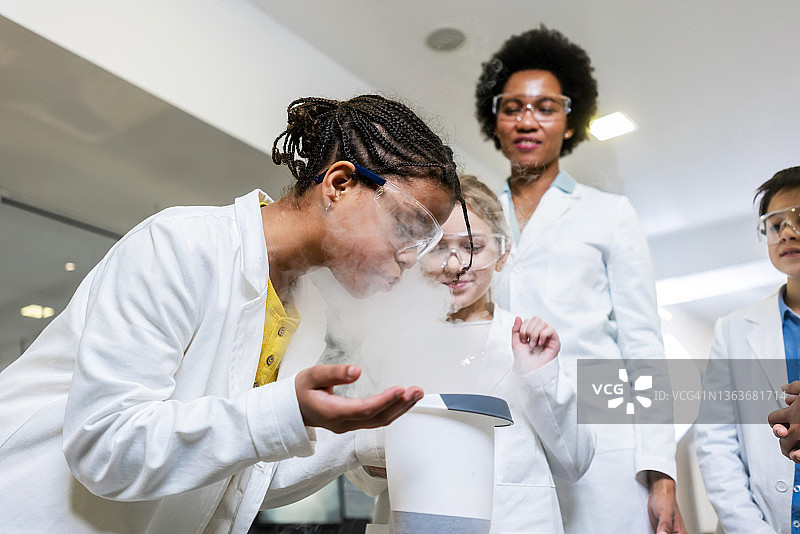 不同的小学生与老师一起进行科学项目图片素材