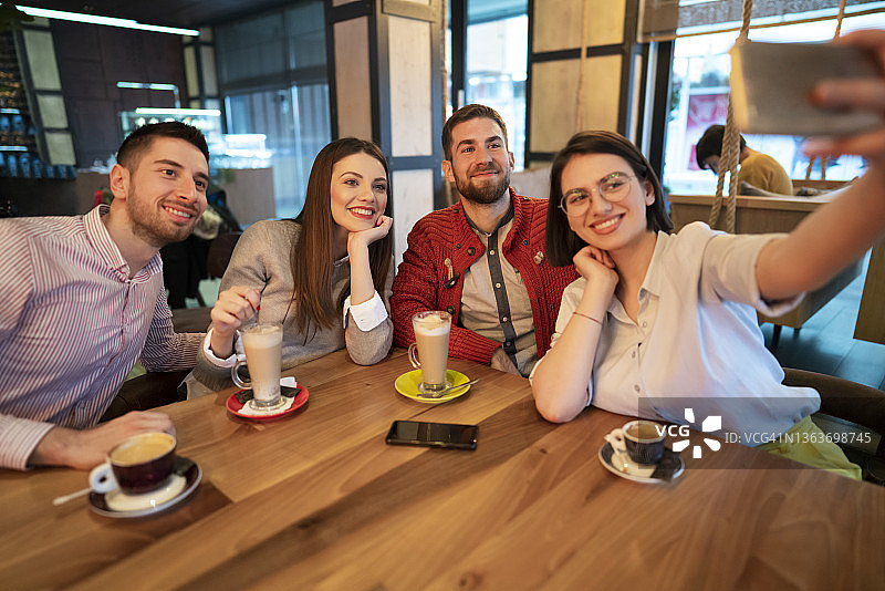 俯视：年轻人在咖啡店自拍图片素材