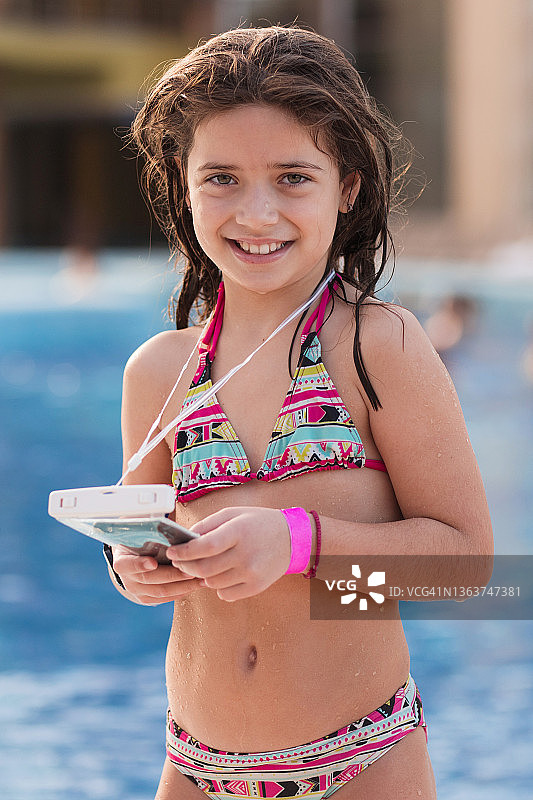 穿着泳衣拿着手机的快乐年轻女孩特写图片素材