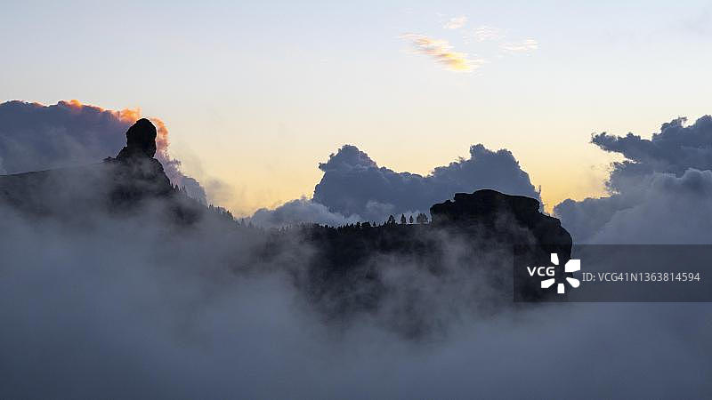 日落时云雾缭绕的罗克·努布洛岩，地标，西班牙加那利群岛大加那利岛图片素材