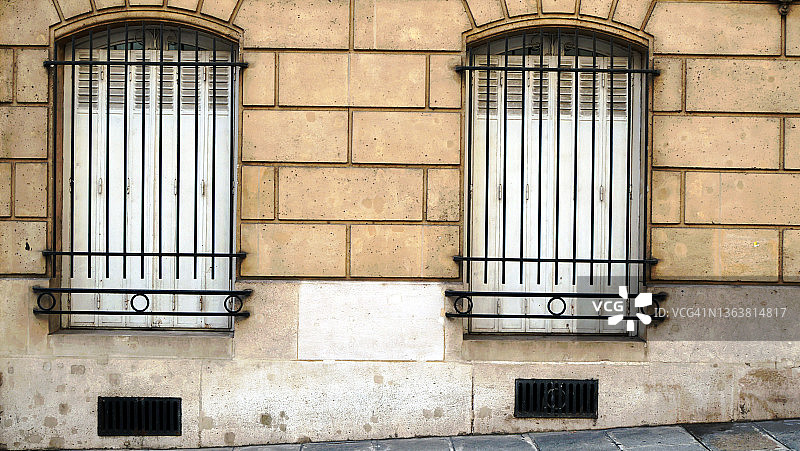 巴黎一栋豪华奥斯曼建筑和人行道的两扇窗户图片素材