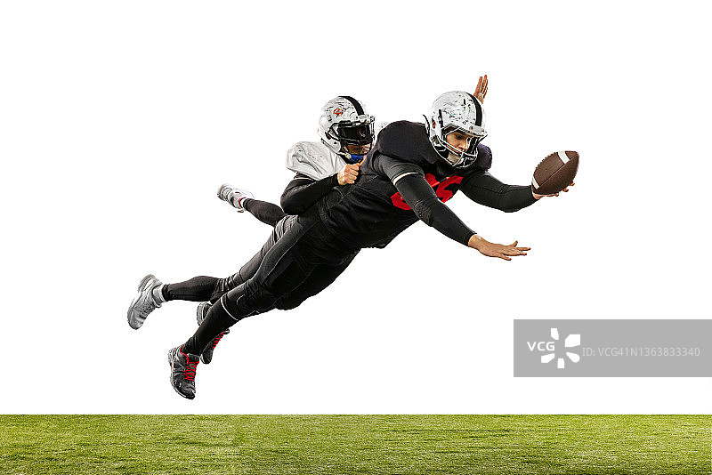 两名美式橄榄球运动员在草地上争球图片素材