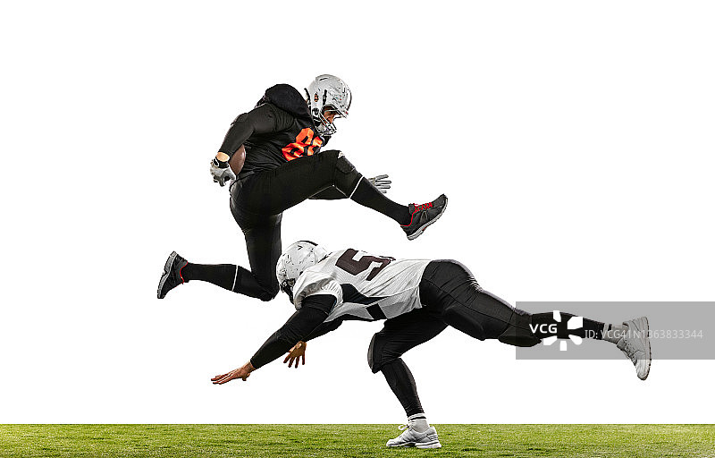 两名美式橄榄球运动员在草地上争球图片素材