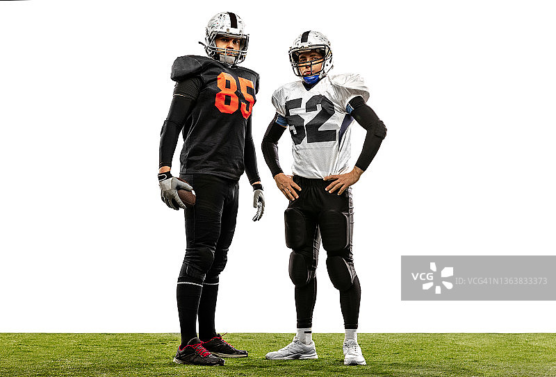 草地上穿运动装备的美式橄榄球运动员人像照片图片素材