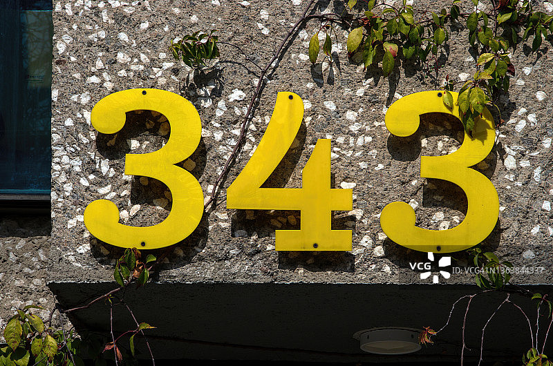 建筑物外墙混凝土墙上的黄色塑料数字343图片素材