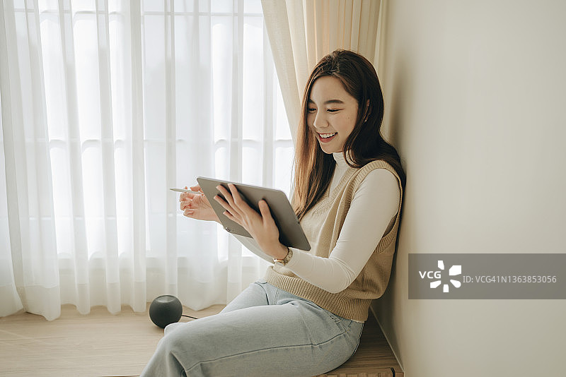 在家用平板电脑工作的年轻亚洲女性图片素材