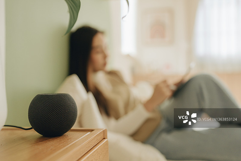 年轻女人用语音助手控制智能家居图片素材