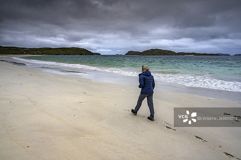 在外赫布里底群岛刘易斯岛海滩上行走的女人图片素材