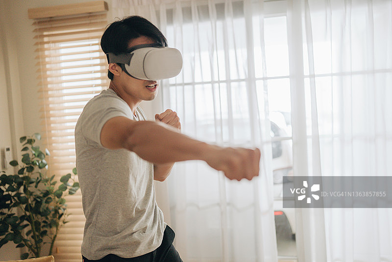 亚洲男人玩VR游戏，元宇宙数字世界AR技术图片素材