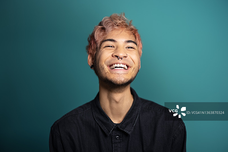 蓝色背景下微笑的年轻男人图片素材