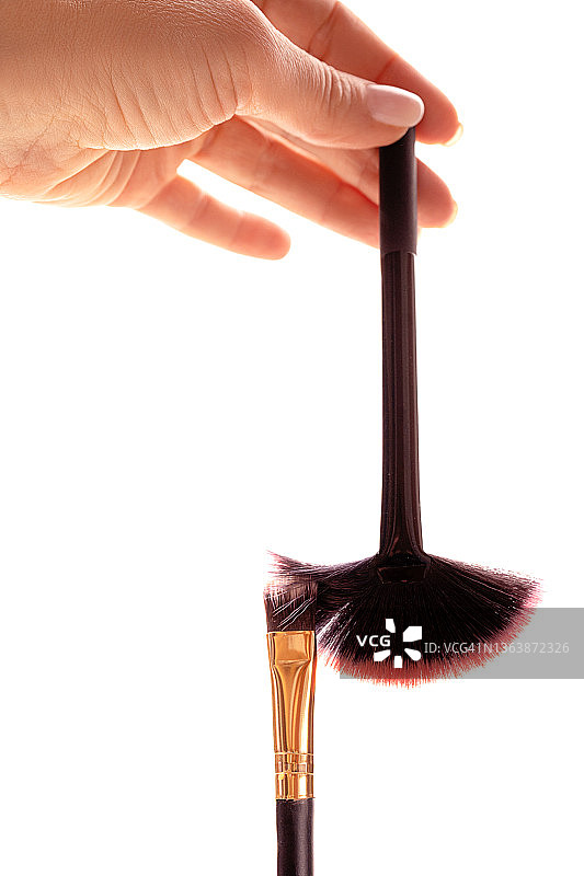 女性手和化妆刷的创意美容构图图片素材