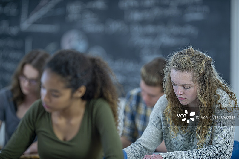 学生在课堂课桌前书写图片素材