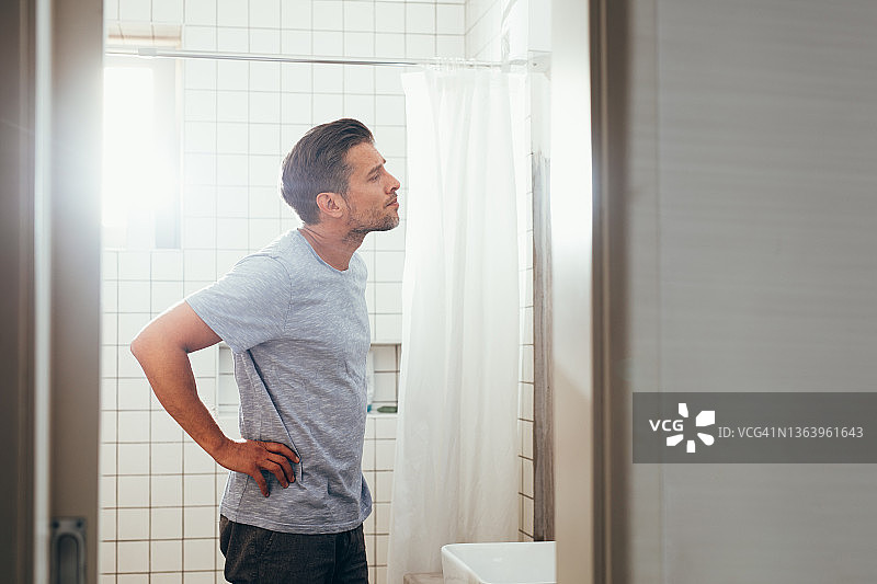 在浴室镜子前整理仪容的男人图片素材