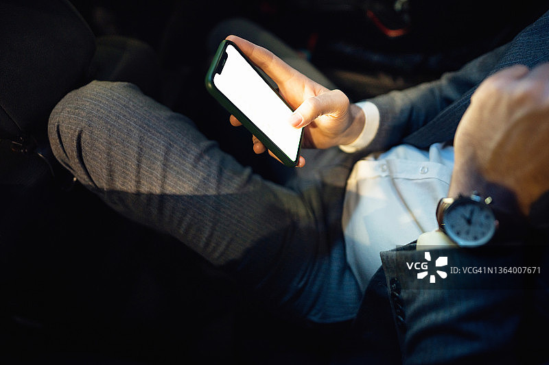 不露面的白人商人深夜坐在车里发短信图片素材