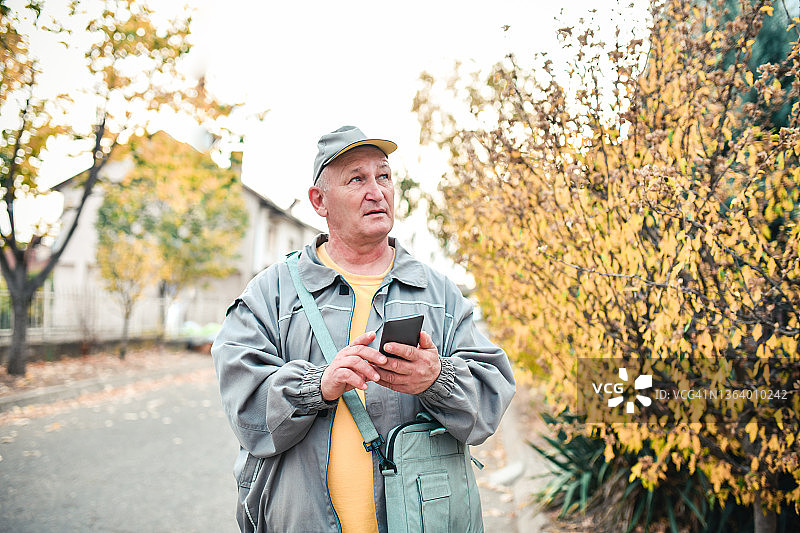邮差与智能手机地图寻找送货地点图片素材