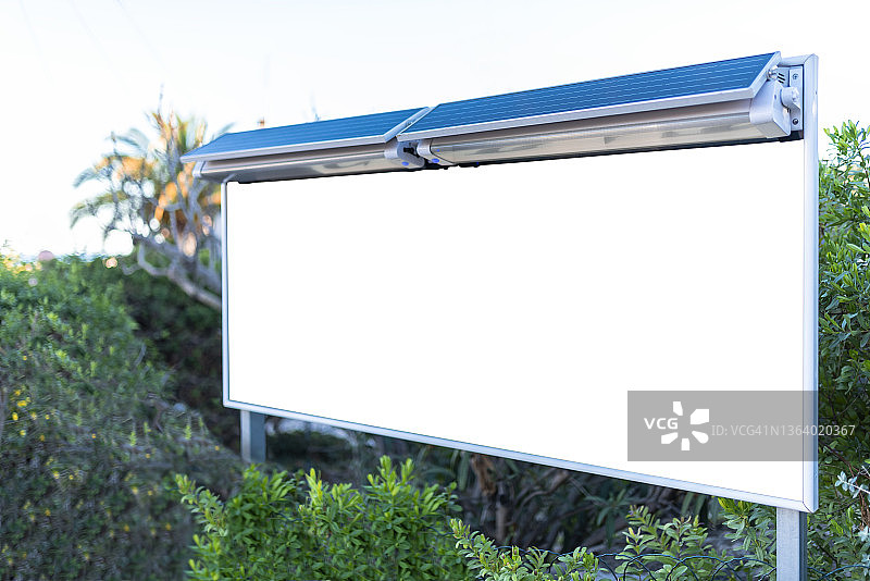 带有太阳能电池板的白色广告牌，用于夜间照明。可持续性图片素材