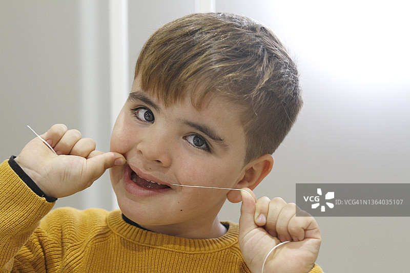 男孩用牙线清洁牙齿图片素材