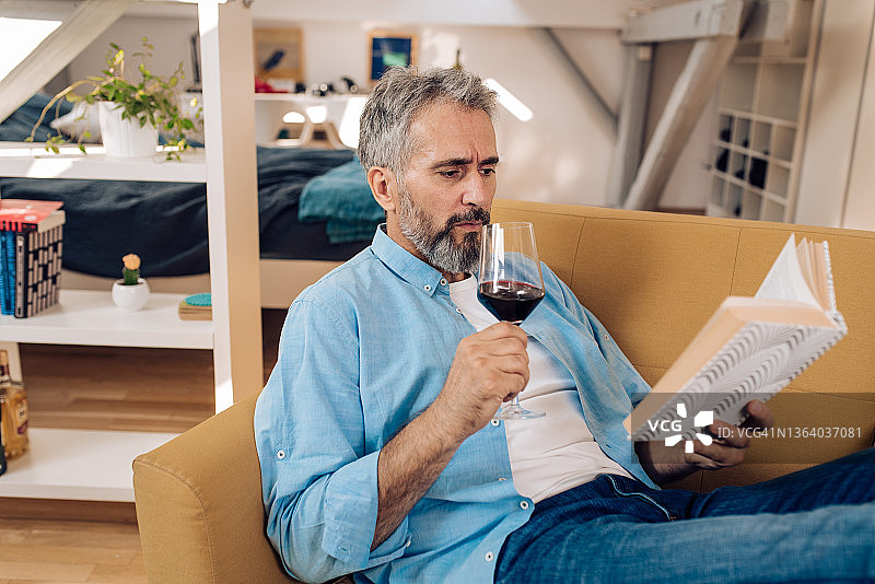 年长的男人在工作后的家庭办公室阅读图片素材