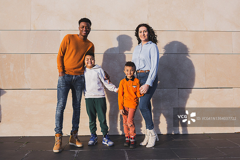 年轻的多种族家庭在砖墙旁图片素材