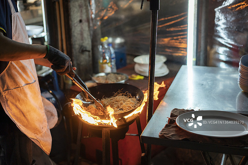 厨师在泰国曼谷耀华乐路户外用炒锅烹饪图片素材