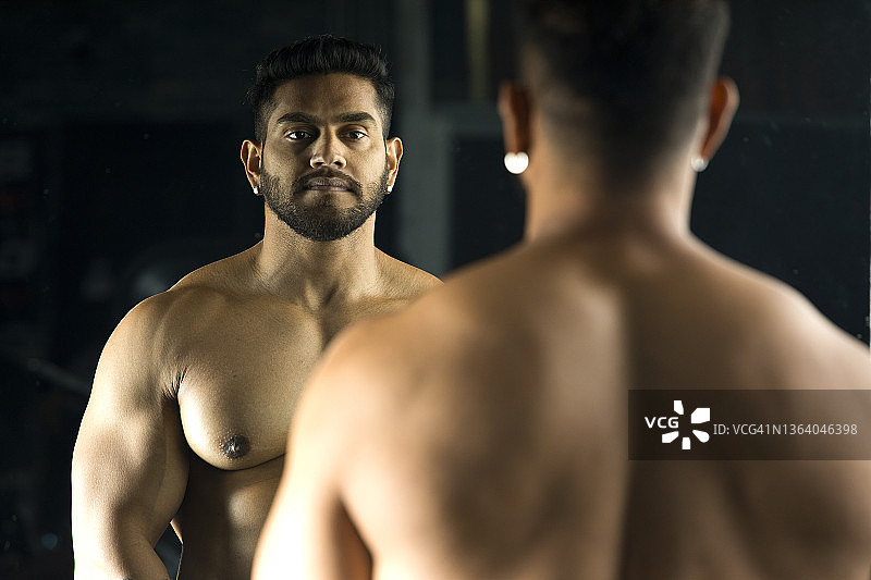 健壮的男人站在镜子前图片素材