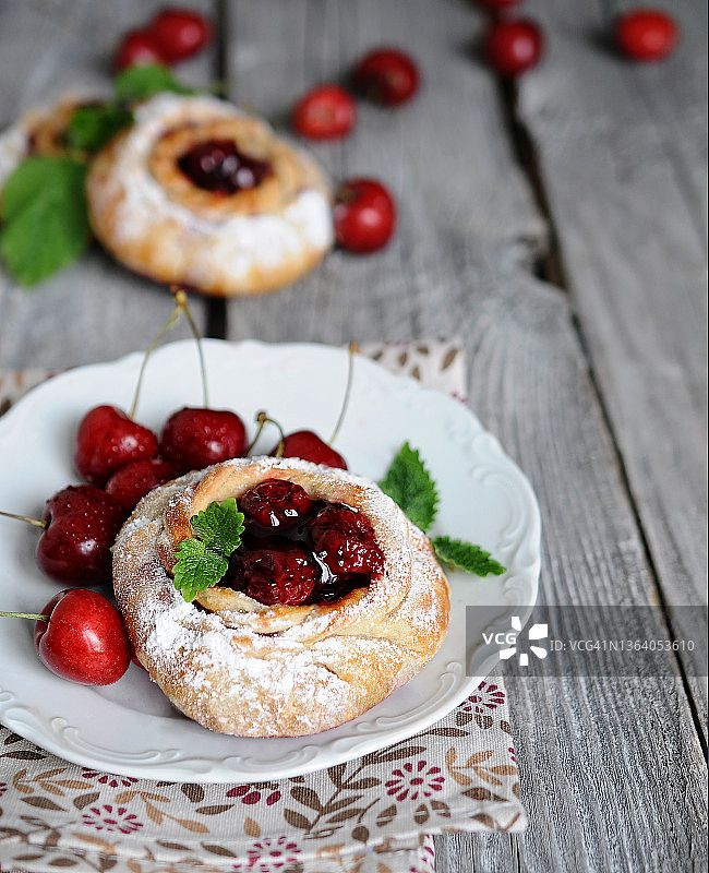 老木桌背景上的樱桃馅自制酥皮包特写图片素材