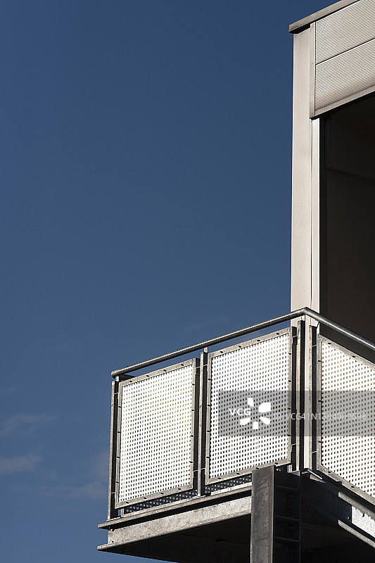 现代建筑的金属消防逃生梯特写，背景为蓝天图片素材