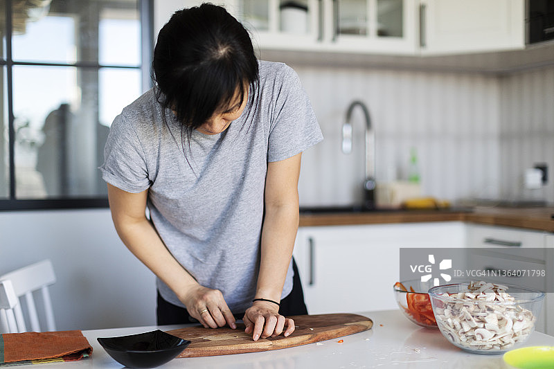 年轻的韩国女人在厨房做纯素食物图片素材