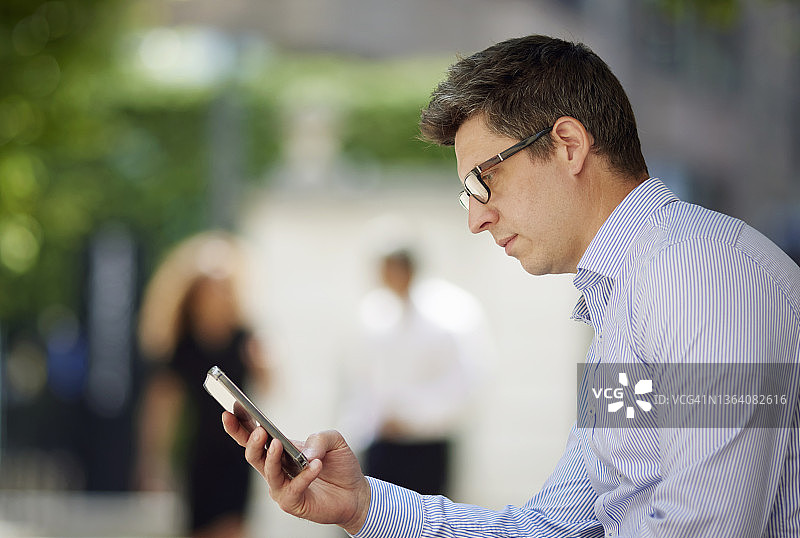 在城市中使用智能手机的商人图片素材