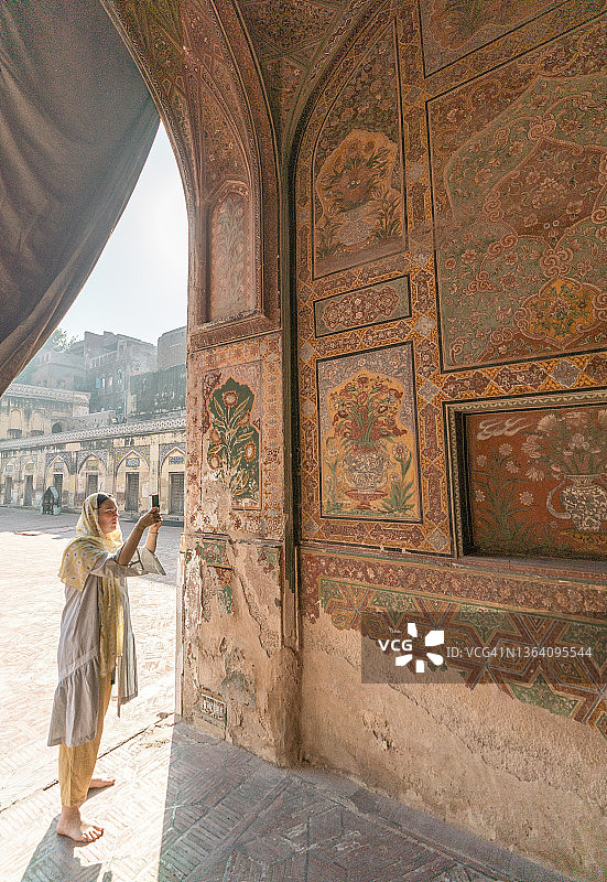 戴着头巾的女人在拍摄清真寺内部图片素材