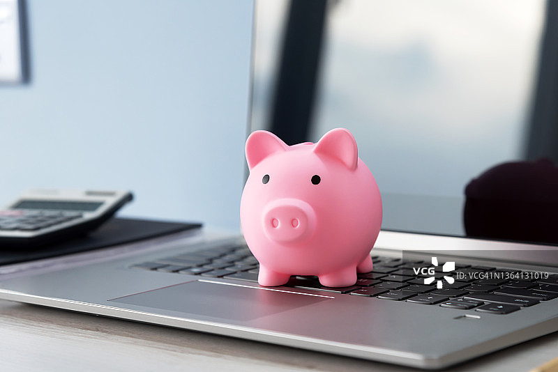 笔记本电脑上的储蓄罐图片素材