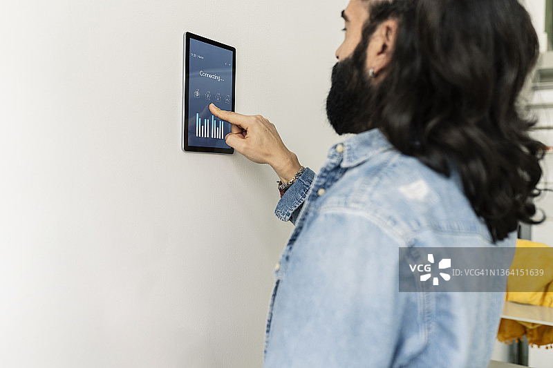 在家使用智能家居平板电脑的中年男人图片素材