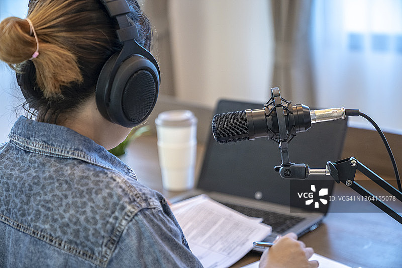 年轻女子在家录制播客的背影图片素材