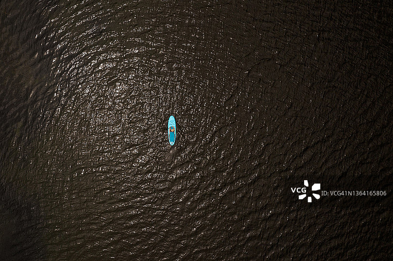 女人在清澈湖泊上桨板运动图片素材