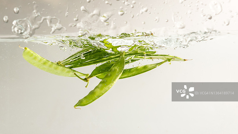 白色背景上水中飞溅的雪豆图片素材