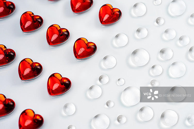 淡灰色背景上的红色心形和水滴图案图片素材